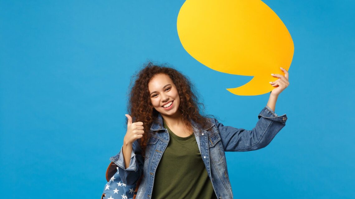 young-african-american-girl-teen-student-denim-clothes-backpack-hold-say-cloud-isolated-blue-wall